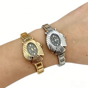 Primo piano di orologi al quarzo ovali a forma di pesce in oro e argento al polso