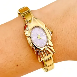 Close-up of ladies gold-tone watch with unique shell case and lavender dial