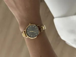Elegant dameshorloge met gouden stalen band en zwarte wijzerplaat met Arabische cijfers