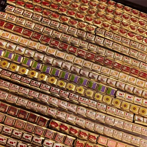 Macro detail of various 18K gold DIY modular bracelet charms in stainless steel