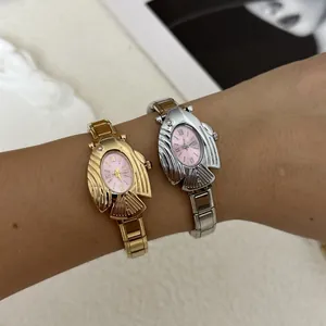 Primo piano di orologi al quarzo a forma di pesce oro e argento con quadranti ovali rosa