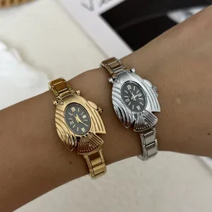 Primo piano di orologi al quarzo ovali a forma di pesce volante in oro e argento