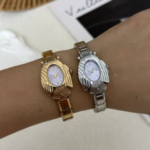 Dettaglio degli orologi al quarzo ovali in oro e argento a forma di pesce volante al polso