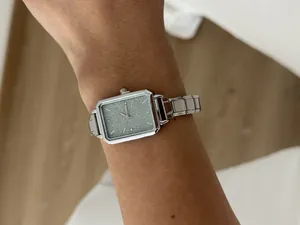 Elegant silver rectangular women's quartz watch with glitter dial shown on a wrist
