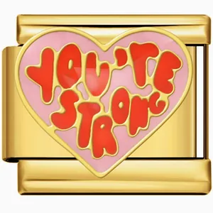 Close-up detail of a gold stainless steel heart charm link with 'YOU'RE STRONG' text.