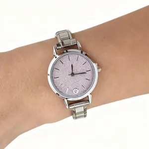 Detailed view of fashionable stainless steel modular watch with pink glitter dial on wrist
