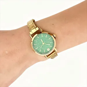 Vintage gold stainless steel modular watch with textured green dial worn on a person's wrist