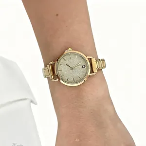 Close-up view of a stylish gold modular stainless steel watch worn on a woman's wrist