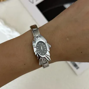 Detailed close-up of a unique silver crab-shaped fashion watch with a black oval dial.