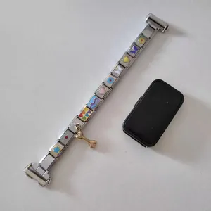 Close-up of stainless steel modular charm watch strap with colorful enamel icons