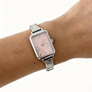 Close-up of a elegant women's quartz watch with pink dial and silver steel band on wrist