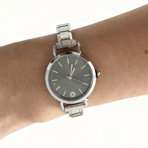 Detailed view of a minimalist silver modular stainless steel watch worn on a wrist