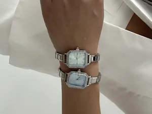 Vue détaillée de deux montres à quartz carrées argentées avec strass au poignet