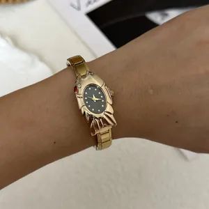 Close-up of a vintage-style gold women's watch with a unique fish-shaped case