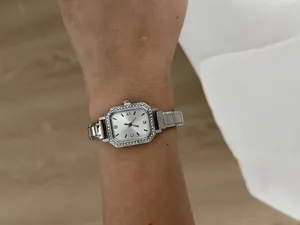 Vue détaillée d'une montre à quartz carrée argentée avec lunette en strass au poignet