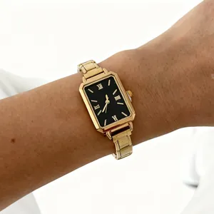 Detailed view of an elegant gold rectangular quartz watch with a black dial on wrist