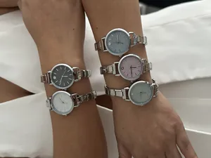 Detailed view of five DIY modular link watches with glitter dials worn on models' arms