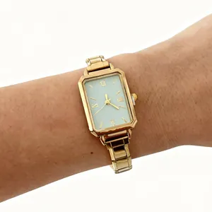 Detail view showing a classic gold steel band ladies' quartz watch worn on a slender wrist
