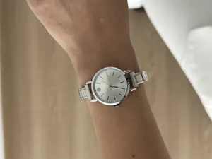 Close-up detail showing a silver vintage stainless steel modular watch worn on a wrist