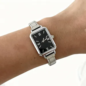 Close-up of a women's silver steel strap quartz watch with a black rectangular dial