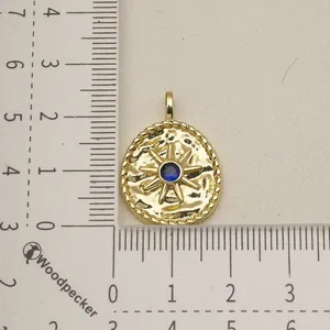 Macro view of a gold stainless steel star charm with a central blue stone for jewelry