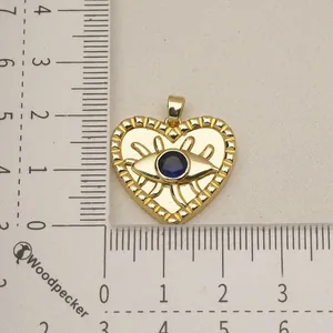 Detail shot of golden stainless steel heart pendant with evil eye on measuring ruler