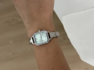 Vue détaillée d'une élégante montre à quartz carrée argentée avec strass sur le poignet