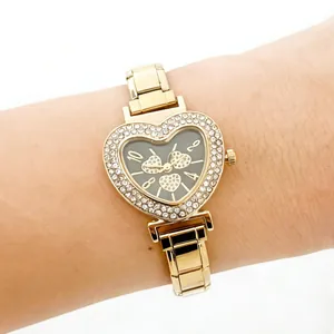 Elegant gold heart-shaped women's watch featuring a sparkling rhinestone bezel on a wrist.