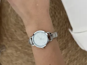 Close-up view of a silver stainless steel modular strap watch with sparkling dial.