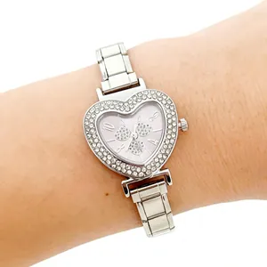 Detailed shot of a silver heart-shaped women's watch with rhinestone bezel and steel strap