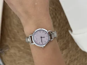 Detailed view of a silver DIY modular stainless steel watch with pink glitter face on wrist