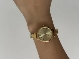 Detailweergave van een goudkleurig kwartshorloge met een modulaire roestvrijstalen band