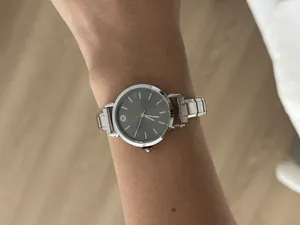 Close-up of a vintage stainless steel modular watch with a grey sunburst dial on a wrist