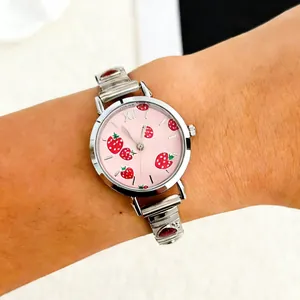 Close-up of a pink dial ladies watch with cute strawberry prints and silver metal band.