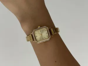 Élégante montre à quartz carrée dorée pour femme avec lunette étincelante en strass