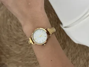 Elegant detail of a gold modular stainless steel watch featuring a silver glitter dial.