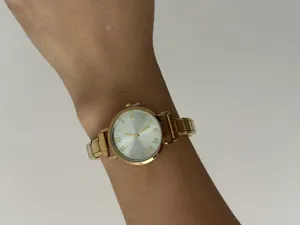 Detailopname van een goudkleurig dameshorloge met modulaire roestvrijstalen schakelarmband