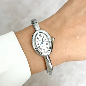 Detailopname van een elegant zilveren dameshorloge met een luxe ovale wijzerplaat