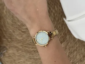 Close-up of gold stainless steel modular watch with a shimmering silver dial