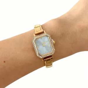 Montre à quartz carrée dorée élégante pour femme avec cadran bleu et lunette en strass.