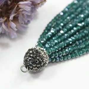 Macro detail of deep green crystal beads and rhinestone-studded tassel cap