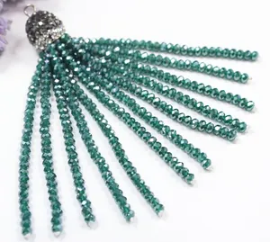 Close-up detail of dark green crystal bead tassel with rhinestone cap for DIY jewelry