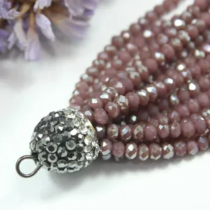 Detailed macro view of mauve faceted crystal bead tassel with sparkling rhinestone cap