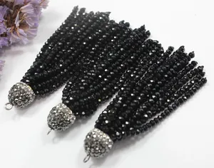 Detailed view of black faceted bead tassels with shimmering rhinestone caps.