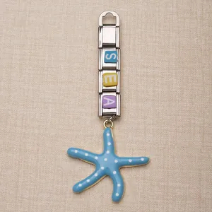 Detail van roestvrijstalen modulaire bedel met 'SEA'-letters en blauwe zeester.