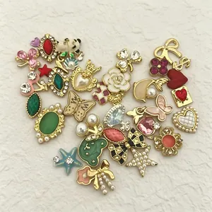 Conjunto de dijes de joyería DIY chapados en oro con cristalli y perlas sobre fondo blanco
