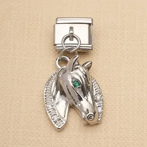 Detailed macro view of silver stainless steel horse head charm with green stone eye