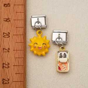 Vue détaillée de breloques italiennes avec pendentifs en émail posées sur une règle