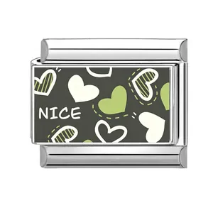 Primer plano de un charm modular plateado con patrones de corazones verdes y blancos