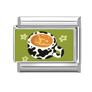 Detalle del dije de taza de café con estampado de vaca para pulsera modular italiana.